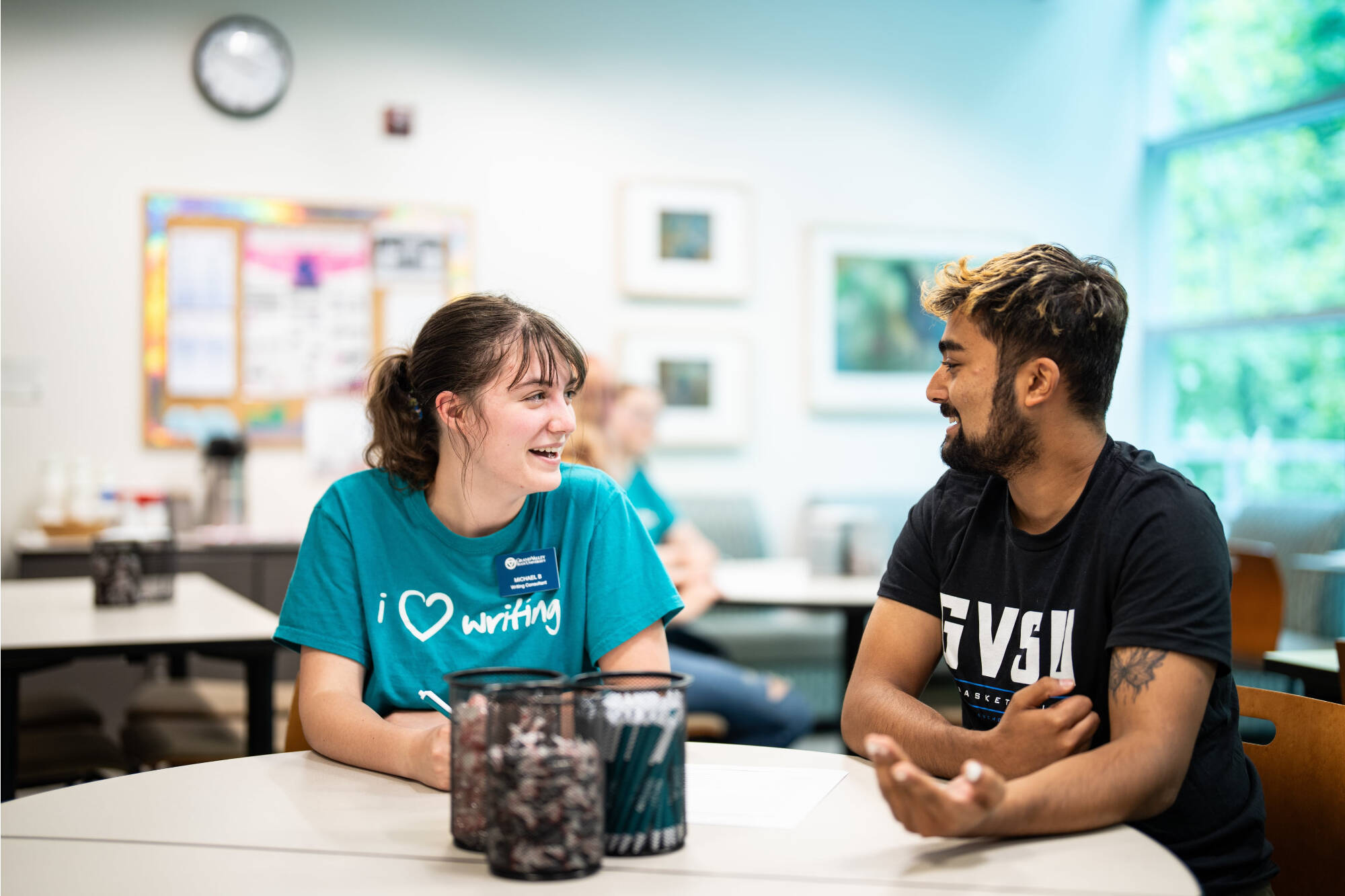 A student and a writing consultant working together at a table